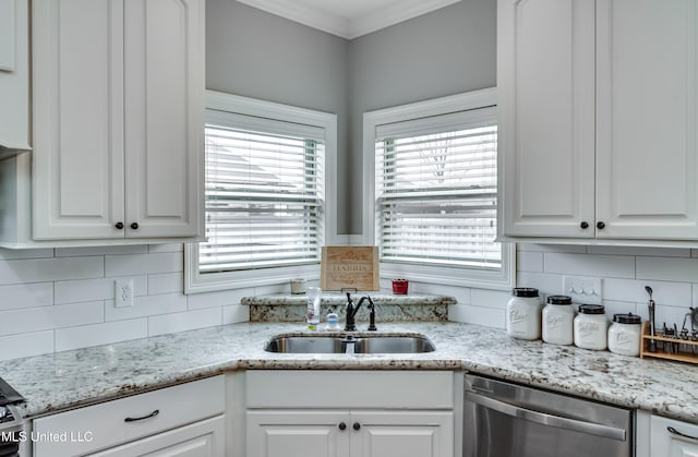 kitchen with sink, stainless steel dishwasher, white cabinets, and decorative backsplash