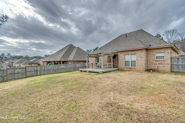 rear view of house featuring a yard and a deck