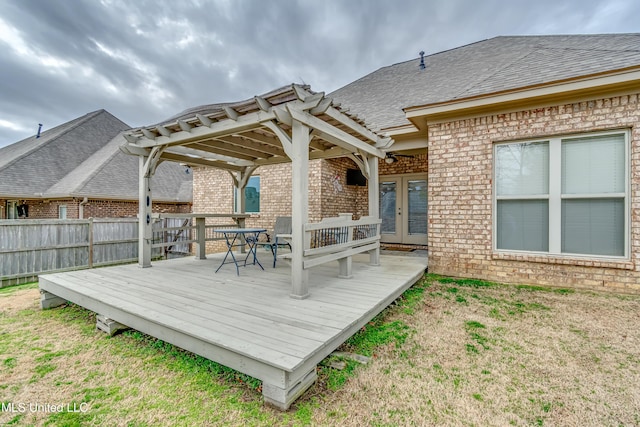 deck with french doors, a yard, and a pergola