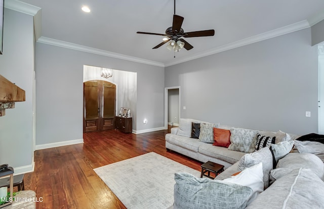 living room featuring dark wood-type flooring, ornamental molding, and ceiling fan