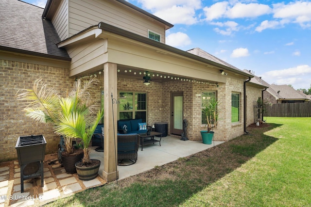 back of house featuring ceiling fan, brick siding, fence, a yard, and outdoor lounge area