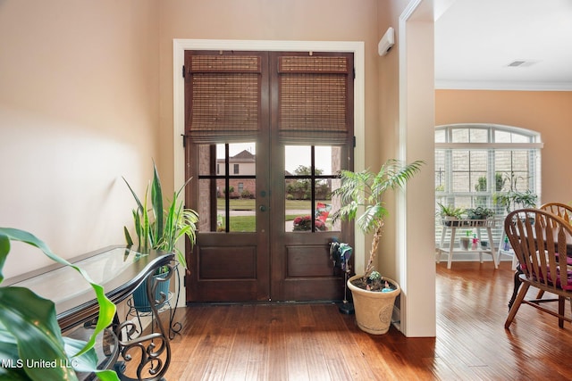 foyer featuring a healthy amount of sunlight, french doors, wood finished floors, and visible vents