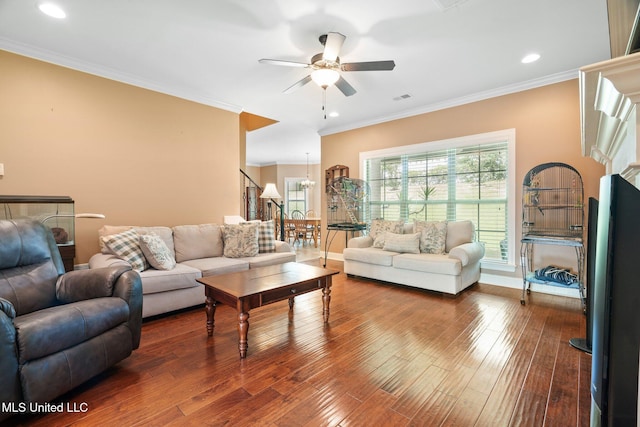 living area featuring crown molding, visible vents, hardwood / wood-style floors, baseboards, and a ceiling fan