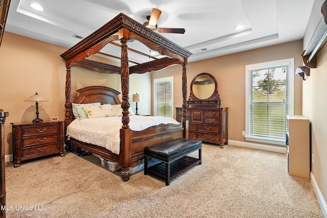 bedroom with visible vents, light colored carpet, a raised ceiling, baseboards, and recessed lighting