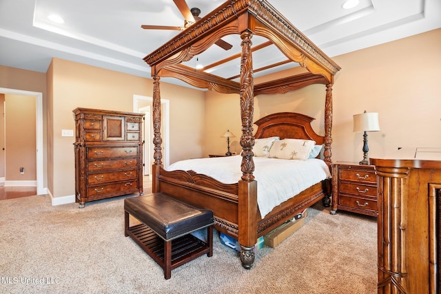bedroom with light colored carpet, recessed lighting, and a tray ceiling