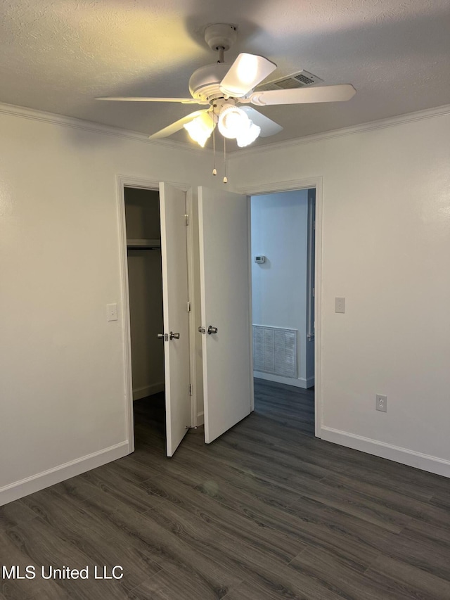 unfurnished bedroom featuring a textured ceiling, ceiling fan, dark hardwood / wood-style flooring, and crown molding