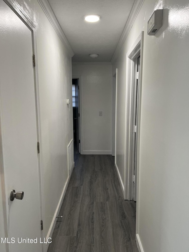 corridor featuring ornamental molding and dark wood-type flooring