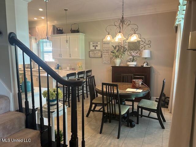 709 Oak Trl, Canton, MS 39046 - dining area with light tile patterned flooring, crown molding, stairs, and a chandelier