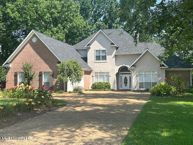 709 Oak Trl, Canton, MS 39046 - traditional-style house with driveway, stucco siding, and brick siding