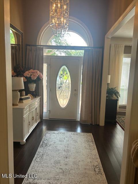 709 Oak Trl, Canton, MS 39046 - foyer entrance featuring a chandelier, plenty of natural light, and dark wood finished floors