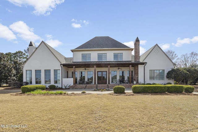 back of property with a lawn, metal roof, a standing seam roof, and ceiling fan