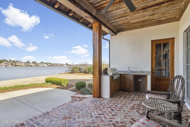 view of patio / terrace with a sink, a water view, and area for grilling