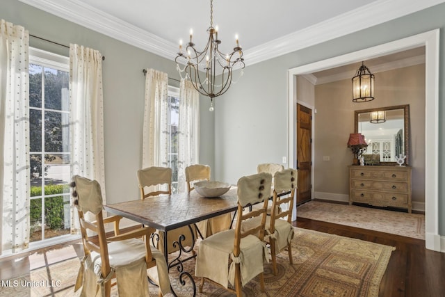 dining space featuring a notable chandelier, ornamental molding, baseboards, and wood finished floors