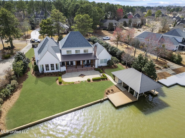 drone / aerial view with a water view and a residential view