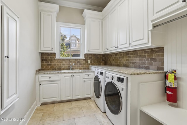 laundry room with cabinet space, light tile patterned floors, independent washer and dryer, and a sink