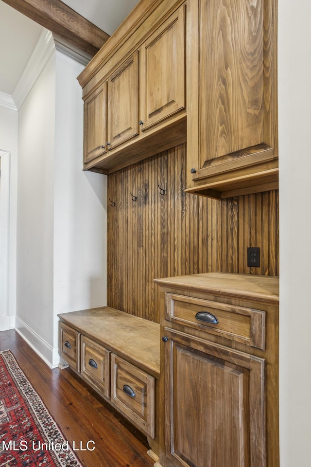 mudroom with ornamental molding, baseboards, and dark wood-style flooring