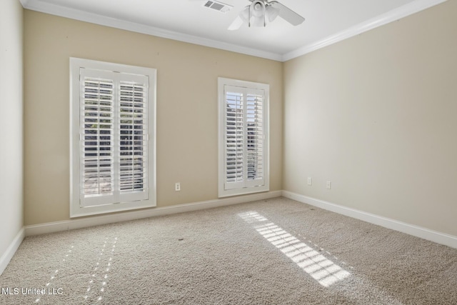 carpeted spare room featuring visible vents, baseboards, crown molding, and ceiling fan