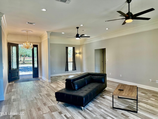 living room featuring plenty of natural light, light hardwood / wood-style floors, ceiling fan with notable chandelier, and ornamental molding