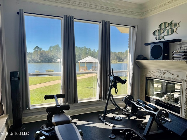 exercise area with a water view and ornamental molding