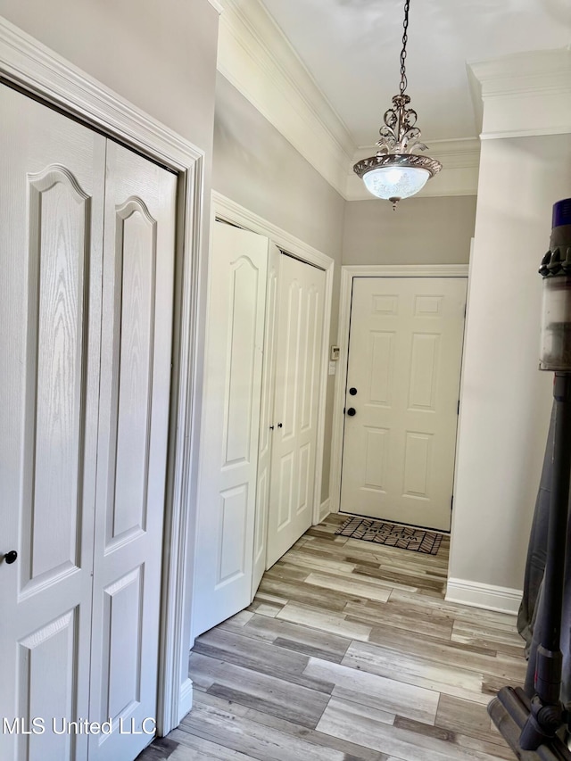 entrance foyer featuring crown molding and light hardwood / wood-style flooring