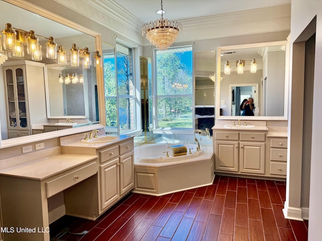 bathroom featuring hardwood / wood-style floors, vanity, crown molding, a washtub, and a notable chandelier