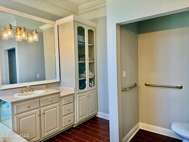 bathroom featuring wood-type flooring, vanity, toilet, and ornamental molding