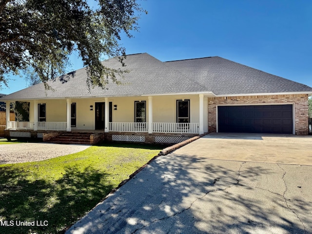 view of front of home featuring a front lawn, covered porch, and a garage