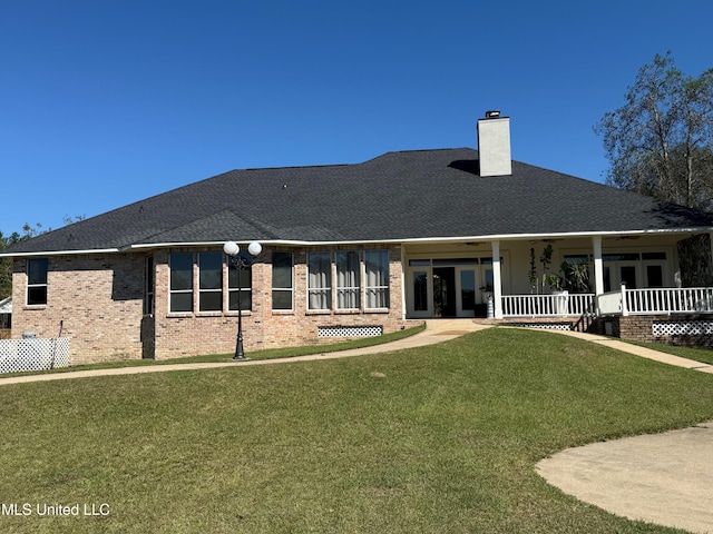 rear view of house featuring a lawn and ceiling fan