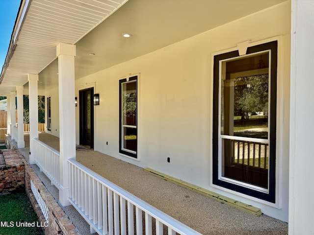 view of exterior entry featuring covered porch