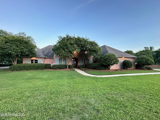 view of front of house featuring brick siding and a front yard