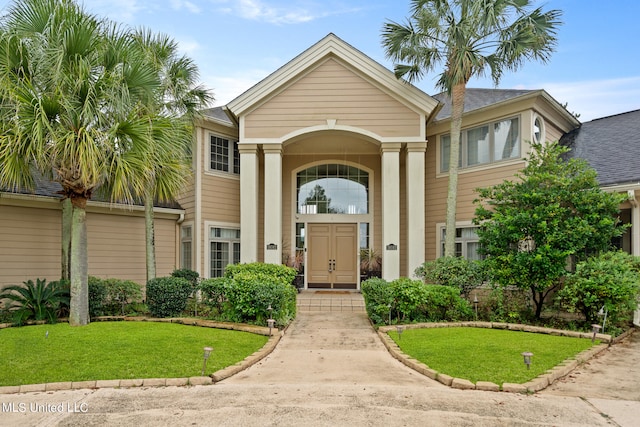 entrance to property with a lawn