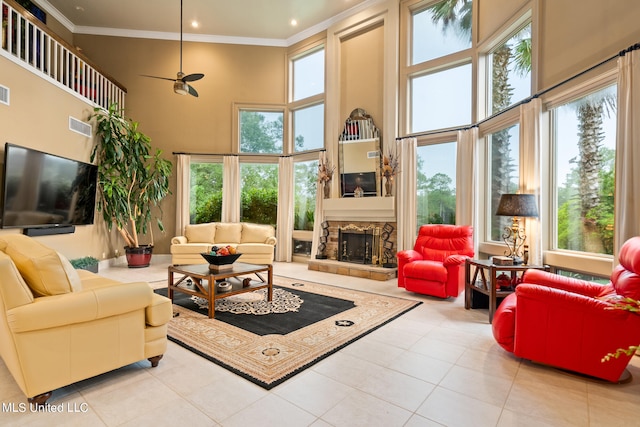 19592 Champion Cir, Gulfport, MS 39503 - tiled living room with crown molding, a towering ceiling, healthy amount of natural light, a stone fireplace, and a ceiling fan