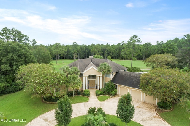 19592 Champion Cir, Gulfport, MS 39503 - view of front facade with an attached garage, a front lawn, driveway, and a view of trees