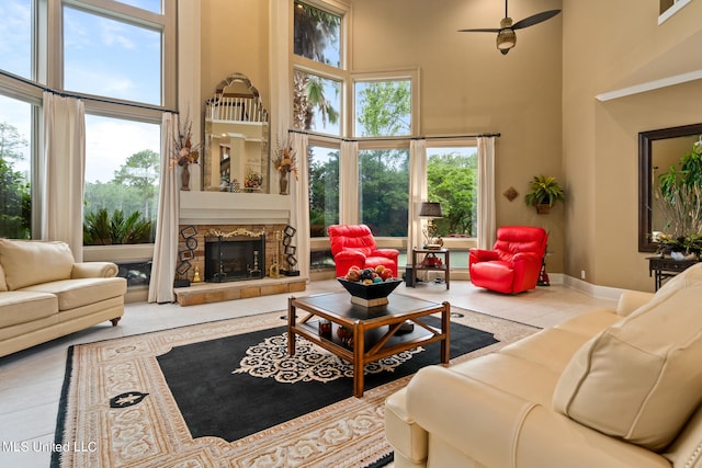 19592 Champion Cir, Gulfport, MS 39503 - tiled living room with a high ceiling, ceiling fan, plenty of natural light, a fireplace, and baseboards