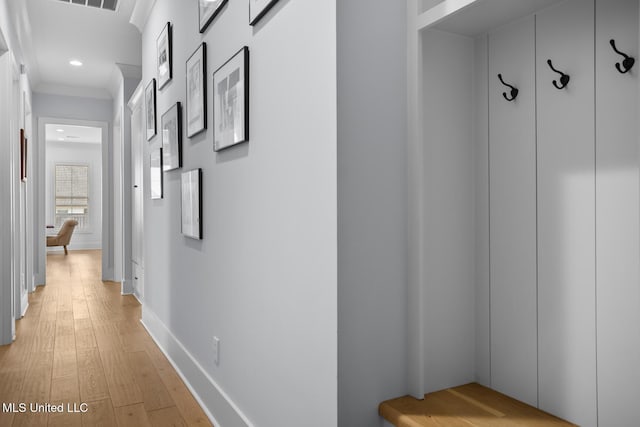 corridor featuring ornamental molding and light wood-type flooring