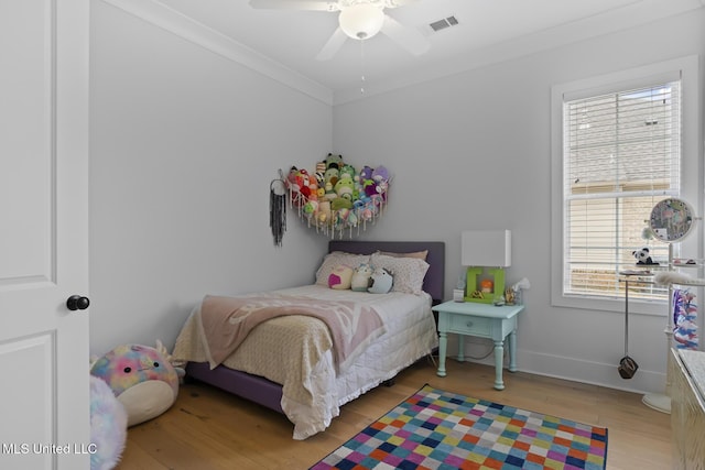 bedroom featuring ceiling fan, ornamental molding, and light hardwood / wood-style flooring