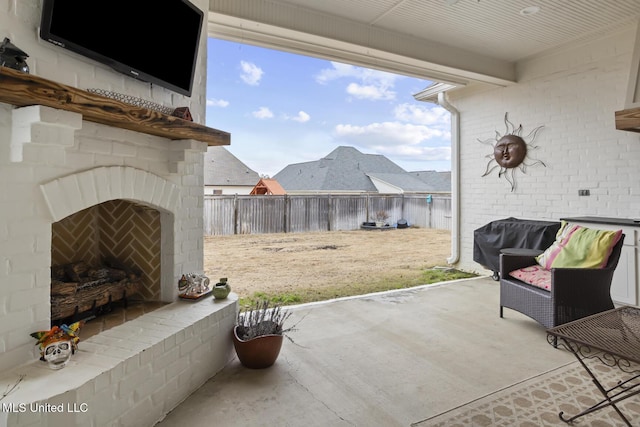 view of patio with an outdoor brick fireplace and a grill