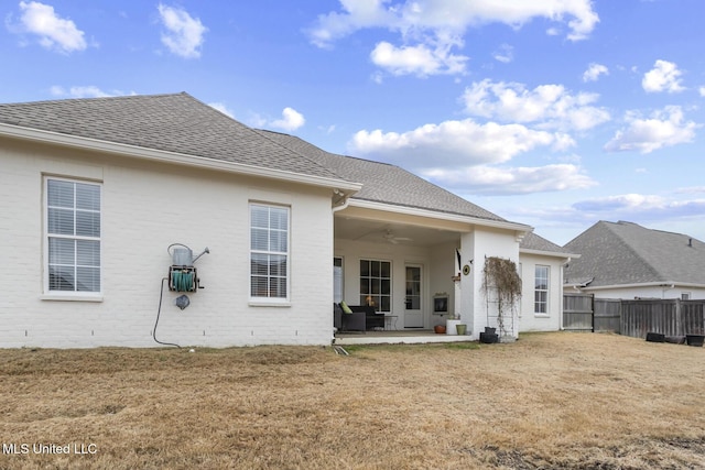 rear view of house featuring ceiling fan, a yard, and a patio