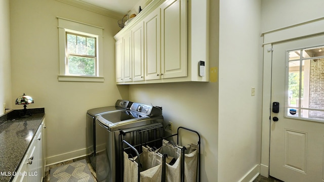 laundry room featuring ornamental molding, cabinets, and independent washer and dryer