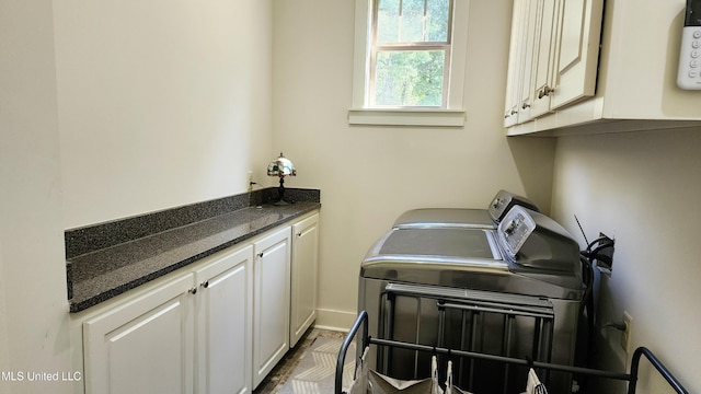 laundry area featuring washer and clothes dryer and cabinets