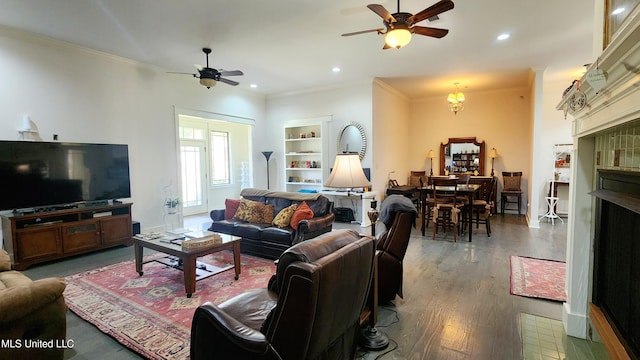 living room with ornamental molding, ceiling fan, and dark wood-type flooring