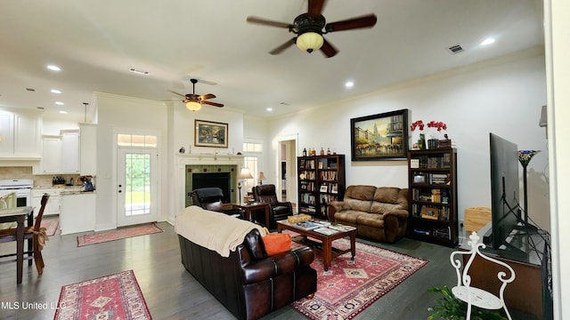 living room featuring ceiling fan, dark hardwood / wood-style flooring, and crown molding