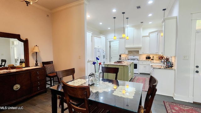 dining area with sink, dark hardwood / wood-style flooring, and crown molding