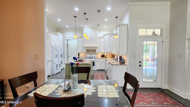 dining space featuring dark hardwood / wood-style floors, ornamental molding, and sink