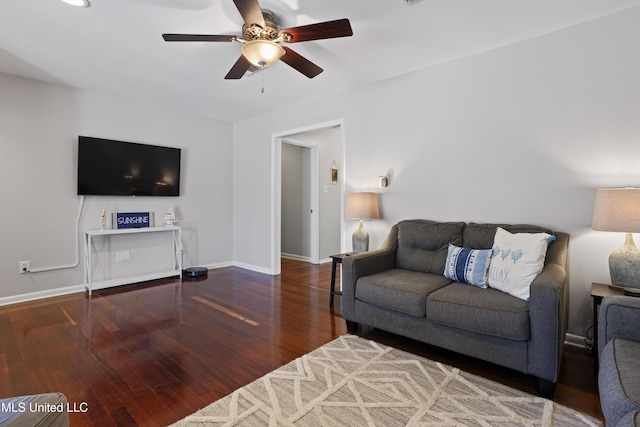 living room featuring ceiling fan, baseboards, and wood finished floors