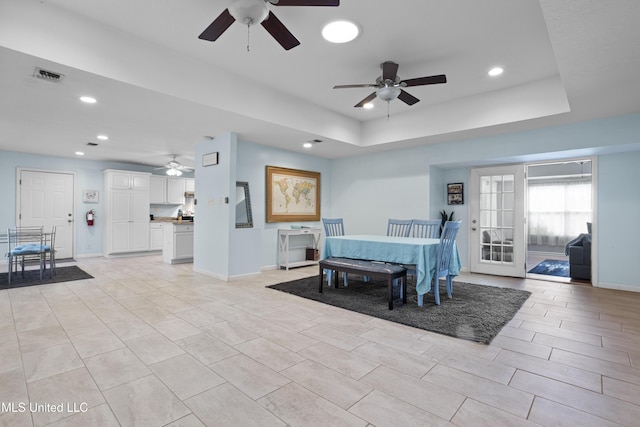 dining space with a tray ceiling, visible vents, baseboards, and recessed lighting