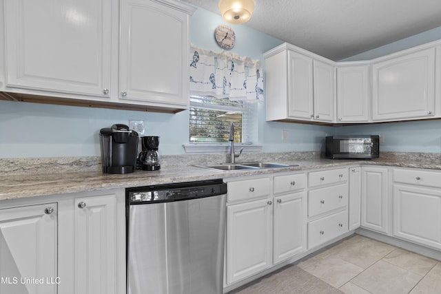 kitchen featuring dishwasher, light tile patterned floors, a sink, and white cabinets