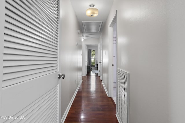 corridor featuring attic access, visible vents, baseboards, and hardwood / wood-style flooring