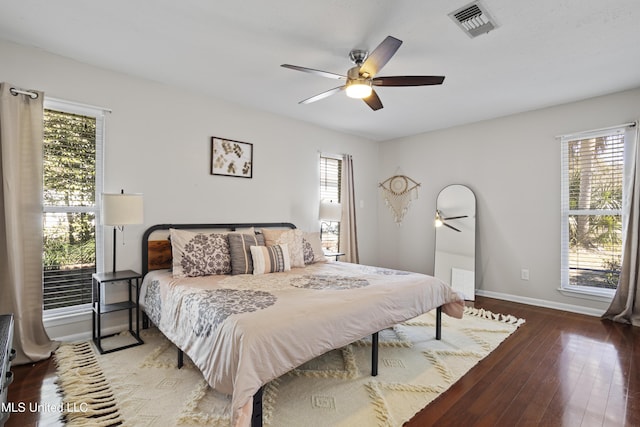 bedroom featuring baseboards, multiple windows, visible vents, and hardwood / wood-style floors