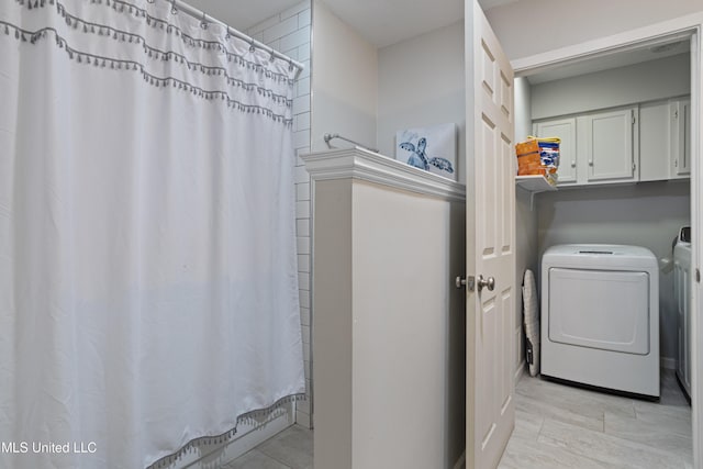 clothes washing area featuring cabinet space and independent washer and dryer